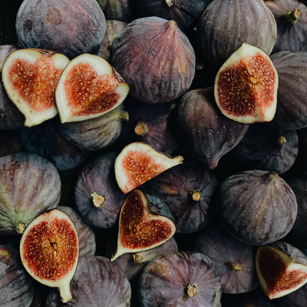 Close-up of fresh whole and halved Brown Turkey figs showing their sweet red interior